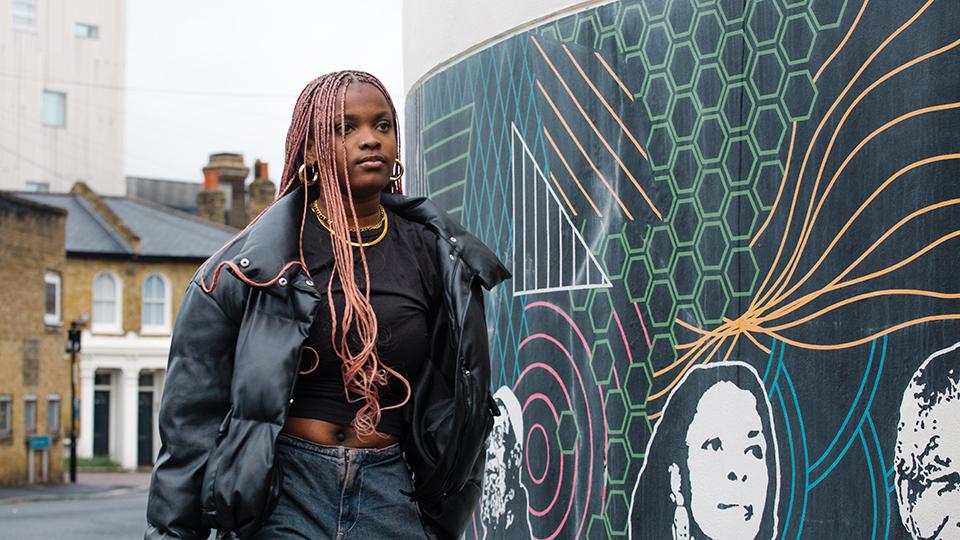 Student walking next to a mural.