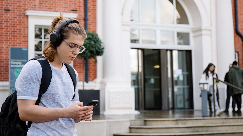 A student on their phone outside the Richard Hoggart Building
