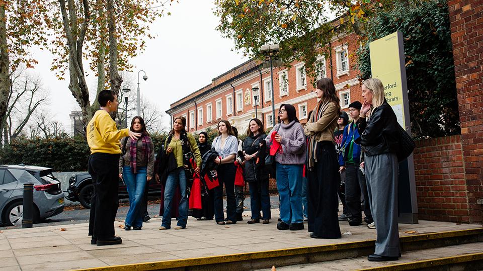 A group of people lead by a student ambassador on a campus tour