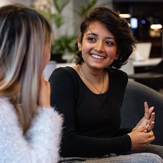 Student smiling at another student.